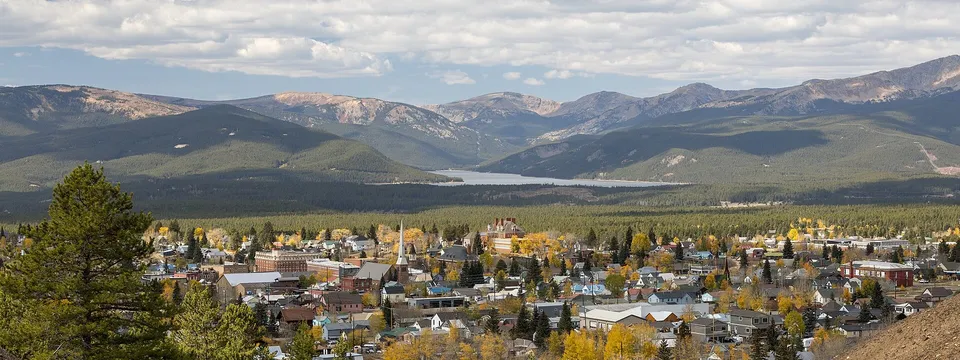 Leadville in autumn among yellow aspens, with Turquoise Lake and the mountains beyond under a cloudy sky