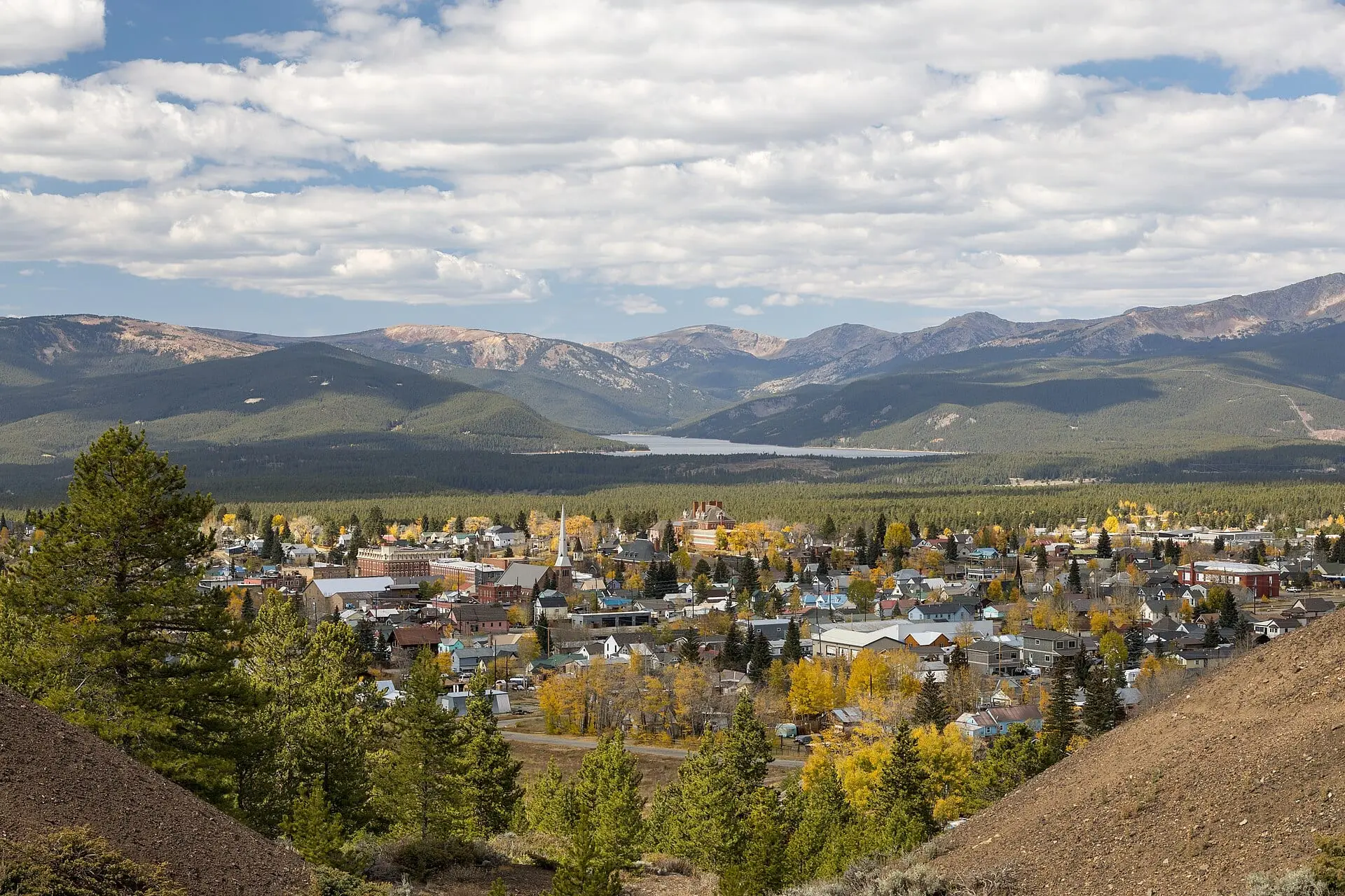 Leadville in autumn among yellow aspens, with Turquoise Lake and the mountains beyond under a cloudy sky
